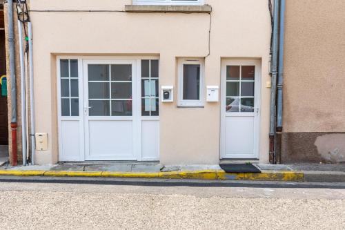 2 portes blanches sur le côté d'un bâtiment dans l'établissement L'Alcove du Pont, à Pont-du-Château