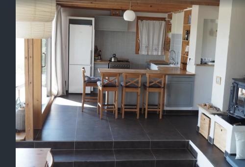 uma cozinha com uma mesa e cadeiras numa cozinha em Les Faveyrolles à Labeaume em Labeaume