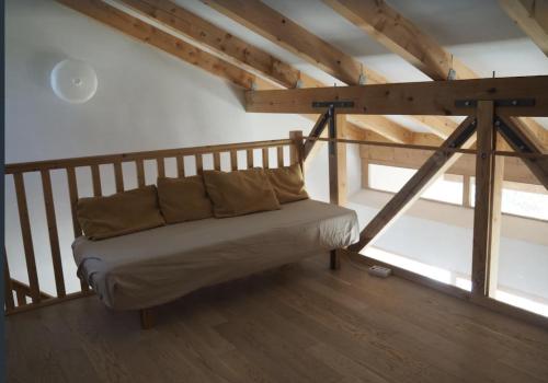 um sofá num quarto com vigas de madeira em Les Faveyrolles à Labeaume em Labeaume