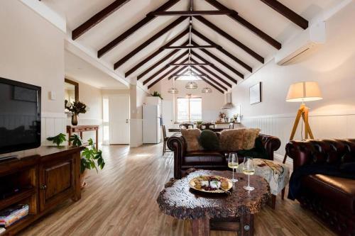 a living room with couches a table and a tv at Maison Magnolia; Character Townhouse in the centre of Margaret River in Margaret River Town