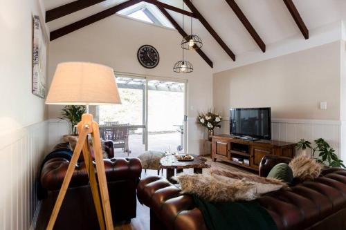 a living room with leather couches and a television at Maison Magnolia; Character Townhouse in the centre of Margaret River in Margaret River Town