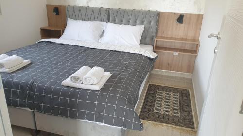 a bedroom with a bed with towels on it at APARTMAN 5 BMB in Veliko Gradište