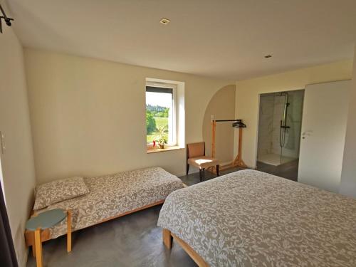 a bedroom with two beds and a window at A l'Orée du Lac, 500m lac de Chamboux in Saint-Martin-de-la-Mer