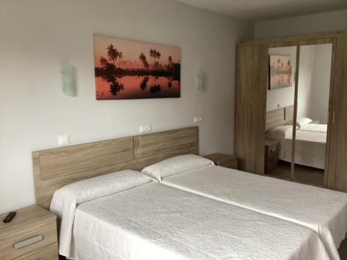 1 dormitorio con cama blanca y espejo en Apartamento Pueblo De Mogro en Mogro