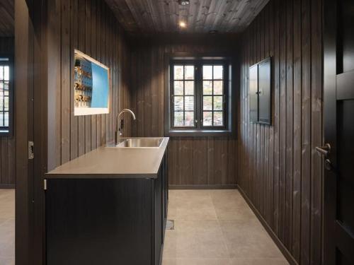 - une grande cuisine avec un évier et des murs en bois dans l'établissement Ny kvalitetshytte-158 m2-Kikut!, à Flatåker