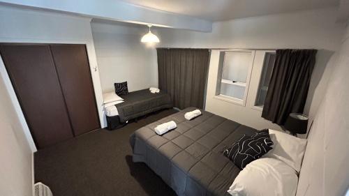 um pequeno quarto de hotel com uma cama e uma janela em Butlers Reef Accommodation em Oakura