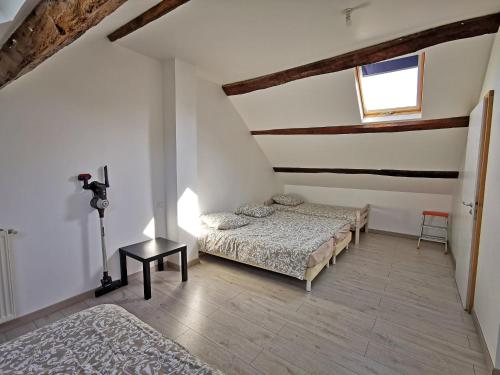 a bedroom with two beds and a table and a window at A l'Orée du Lac, 500m lac de Chamboux in Saint-Martin-de-la-Mer