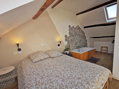 a bedroom with a bed and a bath tub at A l'Orée du Lac, 500m lac de Chamboux in Saint-Martin-de-la-Mer