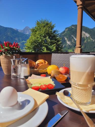 einen Tisch mit Essen und eine Tasse Kaffee darauf in der Unterkunft Hotel Eckartauerhof in Mayrhofen