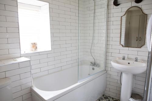 uma casa de banho branca com um lavatório, uma banheira e um WC. em Square & Compass em Two Dales