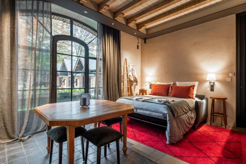 um quarto com uma cama, uma mesa e uma janela em La Petite Ecurie em Saint Malo