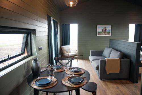 uma sala de estar com duas mesas e um sofá em Sleeping with the Horses em Hvolsvöllur