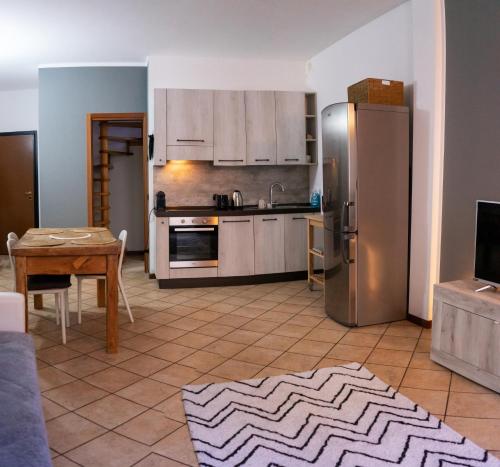a kitchen with a stainless steel refrigerator and a table at La casa di Ale in Lecco