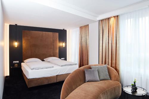 a hotel room with a bed and a chair at Hotel ESPERANTO Kongress- und Kulturzentrum Fulda in Fulda