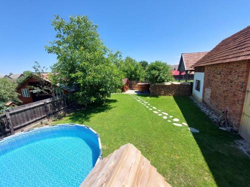 a backyard with a blue pool in the yard at Casuta De Sub Munte Cârțișoara in Cîrţişoara