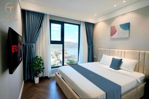 a bedroom with a bed with a large window at Armin Homes Altara Residences Quy Nhon in Quy Nhon