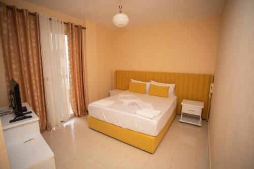 1 dormitorio con 1 cama y TV en Hotel Sunrise, en Golem