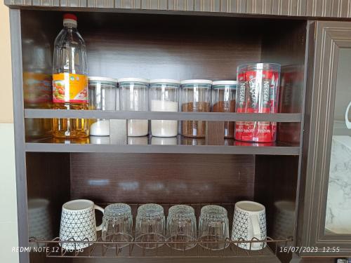 a shelf with cups and other items on it at Cinoiva Homestay Gambang, Kuantan in Gambang