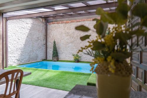 una piscina en un patio con una mesa y una planta en El Pajar de Neme, en Trescasas