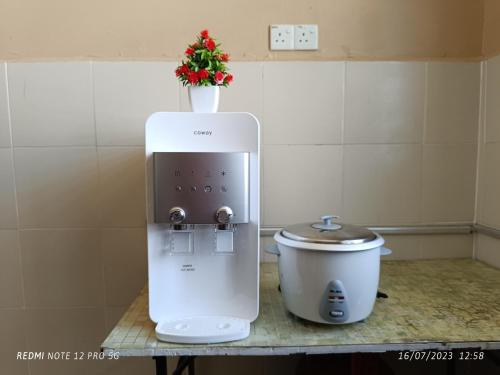 a small appliance on a counter next to a slow cooker at Aras G Homestay in Gambang