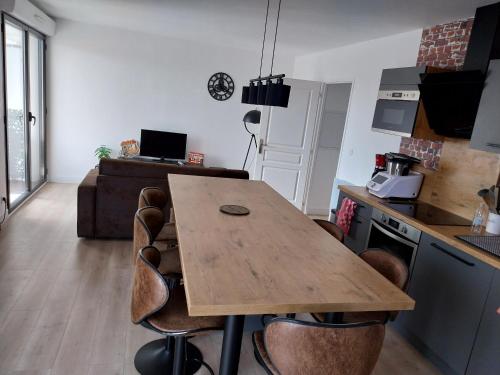 une cuisine avec une table en bois et quelques chaises dans l'établissement Confort au pied du tram, à Bordeaux