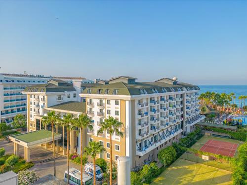 an aerial view of a hotel with palm trees and the ocean at Meryan Hotel - Ultra All Inclusive in Okurcalar