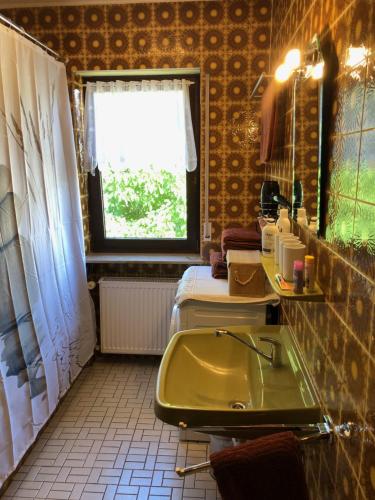baño con lavabo verde y cama en GERBER Ferienwohnung, en Bretzenheim