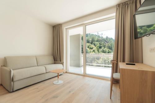 a living room with a couch and a large window at Anett hotel in Vipiteno