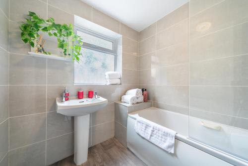 a white bathroom with a sink and a bath tub at Shalom 3 bed Sleeps 5 - Ideally Located in Hull in Hull