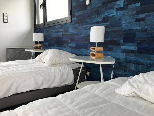 - une chambre avec 2 lits et 2 tables avec des lampes dans l'établissement Ty Rosa, à Plouha