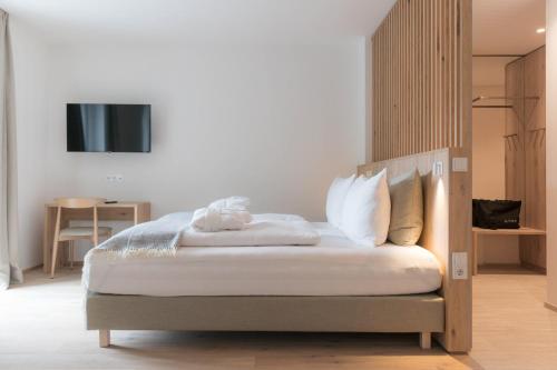 a bedroom with a bed with a tv on the wall at Anett hotel in Vipiteno