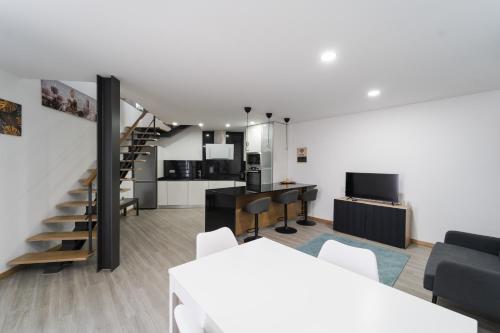a living room with a staircase and a kitchen at Refúgio da Cabreira in Vieira do Minho