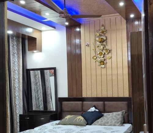 Schlafzimmer mit einem Bett mit einem Spiegel und einer Decke in der Unterkunft Luxurious 3 BHK Flat in Ghaziabad in Ghaziabad