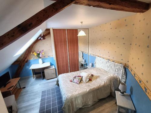 a bedroom with a bed and a desk in a attic at chez jocelyne la bonnaventure in Mazangé