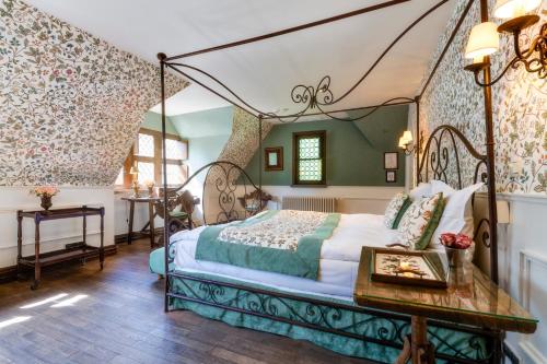 a bedroom with a canopy bed and a table at B&B Exclusive Guesthouse Bonifacius in Bruges