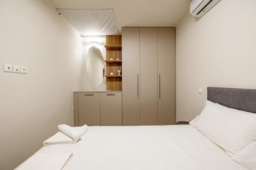 a small bedroom with a bed and a cabinet at Renovated 1st-floor apt-close to the park in Athens