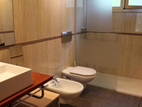 a bathroom with a white toilet and a sink at Homing Golf Bonmont 12 in Bonmont Terres Noves
