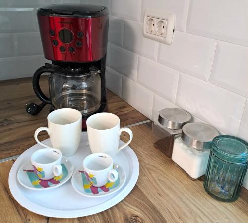 two cups on a plate next to a coffee maker at Imperium Residence in Sfîntu Ilie