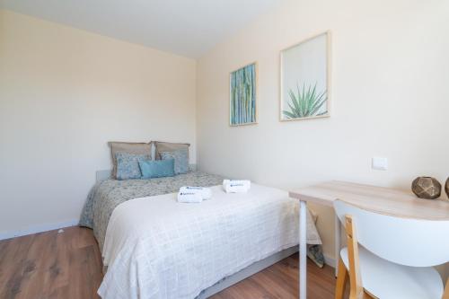 a small bedroom with a bed and a desk at Host Wise - Fantastic Contemporary Flat w Balcony in Porto