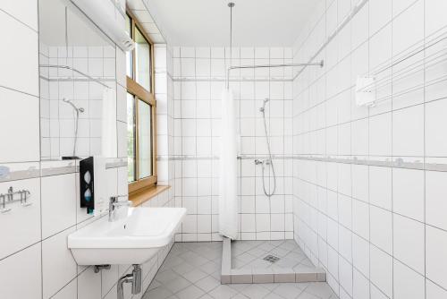 bagno bianco con lavandino e doccia di Kurgo Villa hotel a Pärnu