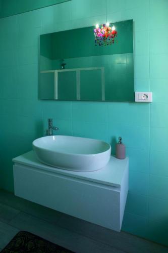 a bathroom with a white sink and a mirror at KOMOREBI Cinque Terre & Lunigiana in Ceparana
