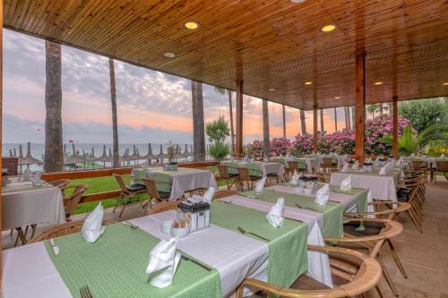 a restaurant with tables and chairs with a view of the ocean at Meryan Hotel - Ultra All Inclusive in Okurcalar