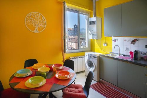 a kitchen with a table with plates and bowls on it at KOMOREBI Cinque Terre & Lunigiana in Ceparana