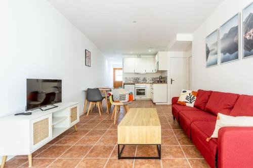 un salon avec un canapé rouge et une table dans l'établissement Joli appartement avec jardin / Vieux-Lormont, à Lormont