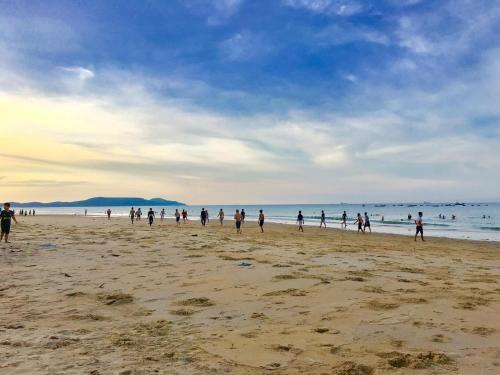 a group of people walking on the beach at HomeStay Ông Vinh 