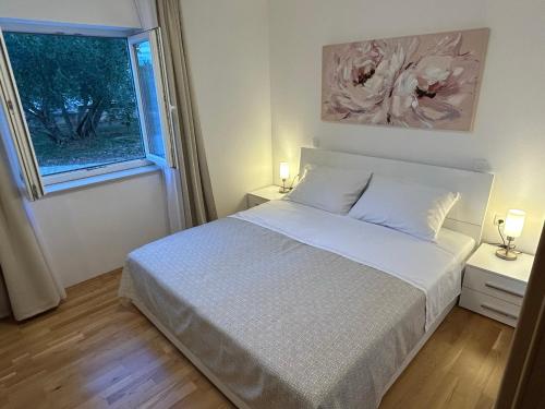 a bedroom with a white bed and a window at Sweet Lapat by EL-PI TOURS in Porat