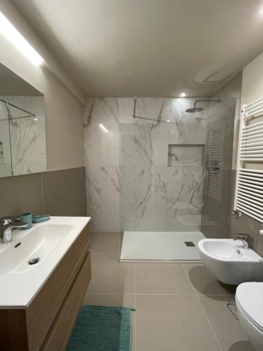 een badkamer met een wastafel, een toilet en een douche bij AEapartmentsaosta in Aosta
