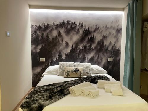 a bedroom with two beds with a painting on the wall at AEapartmentsaosta in Aosta