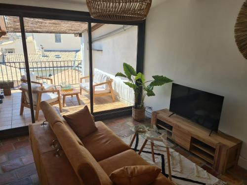 a living room with a couch and a flat screen tv at Nî'douillet-P3 Terrasse et climatisé-coeur de ville in Nîmes