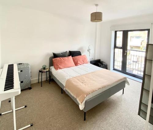 a bedroom with a bed and a piano in it at Large 2bed flat near TowerBridge in London
